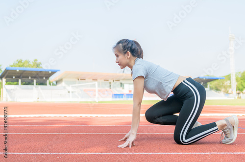Asian cute athlete on a race track is ready to run,