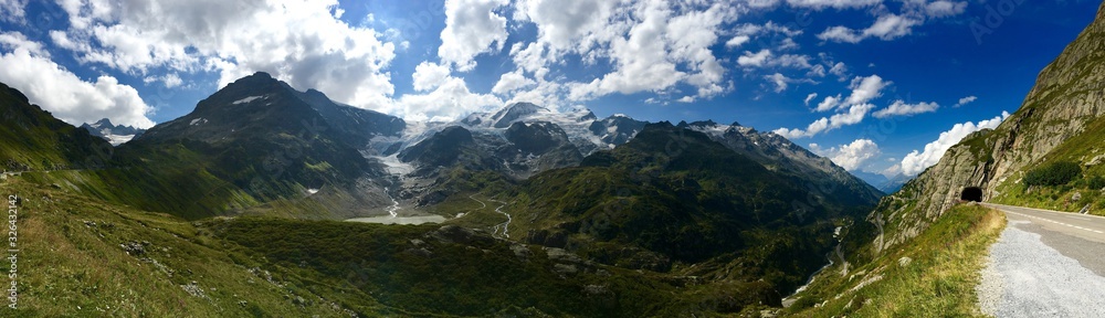 Vista panoramica de los alpes suizos y un valle con un tunel para que pase la carretera