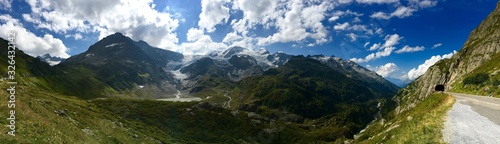 Vista panoramica de los alpes suizos y un valle con un tunel para que pase la carretera