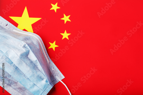 Medical mask on the background of the Chinese flag. Disposable face masks for viruses, Coro novirus. photo