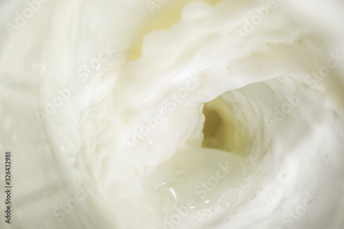 Splashes of liquid milk with foam and bubbles is macro