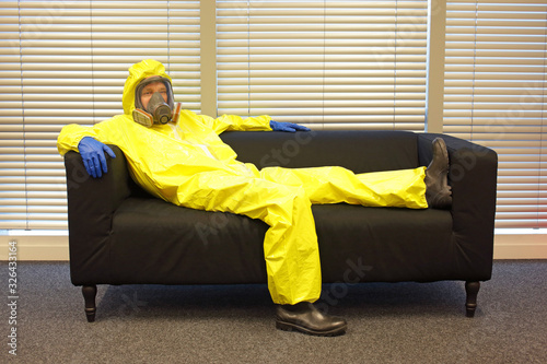 Quarantine - home arrest -  professional in protective clothing, lying  on the sofa and doing nothing © endostock