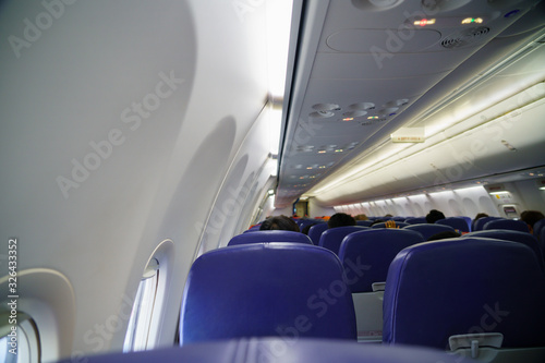 The inside view of the plane That shoots from the back with blue seats that are flying and traveling to destinations of travelers.