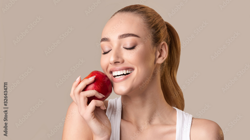 Woman Biting Red Apple Posing Standing Over Beige Background Woman Biting Red Apple Posing Standing Over Beige Background
