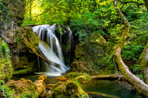 Long exposure of the beautiful La Vaioaga waterfall with green moss, Beusnita, Cheile Nerei National Park, Caras Severin, Romania photo