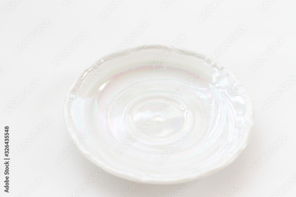 white mother-of-pearl biscuit saucer from a kitchen set on a white background white mother-of-pearl biscuit saucer from a kitchen set on a white background