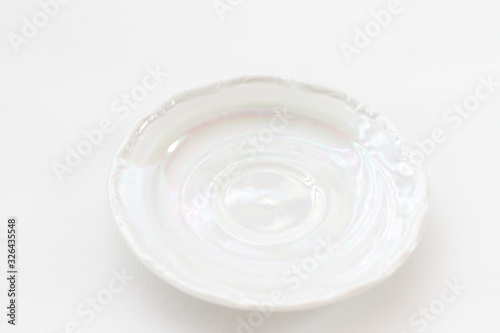 white mother-of-pearl biscuit saucer from a kitchen set on a white background