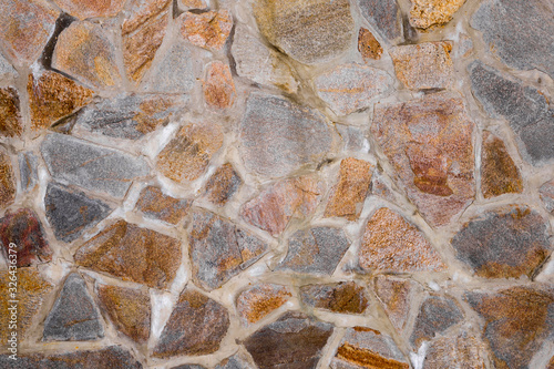 Texture of the wall made of granite stones. Construction .