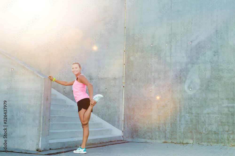 Fototapeta premium Portrait of young attractive woman stretching her legs