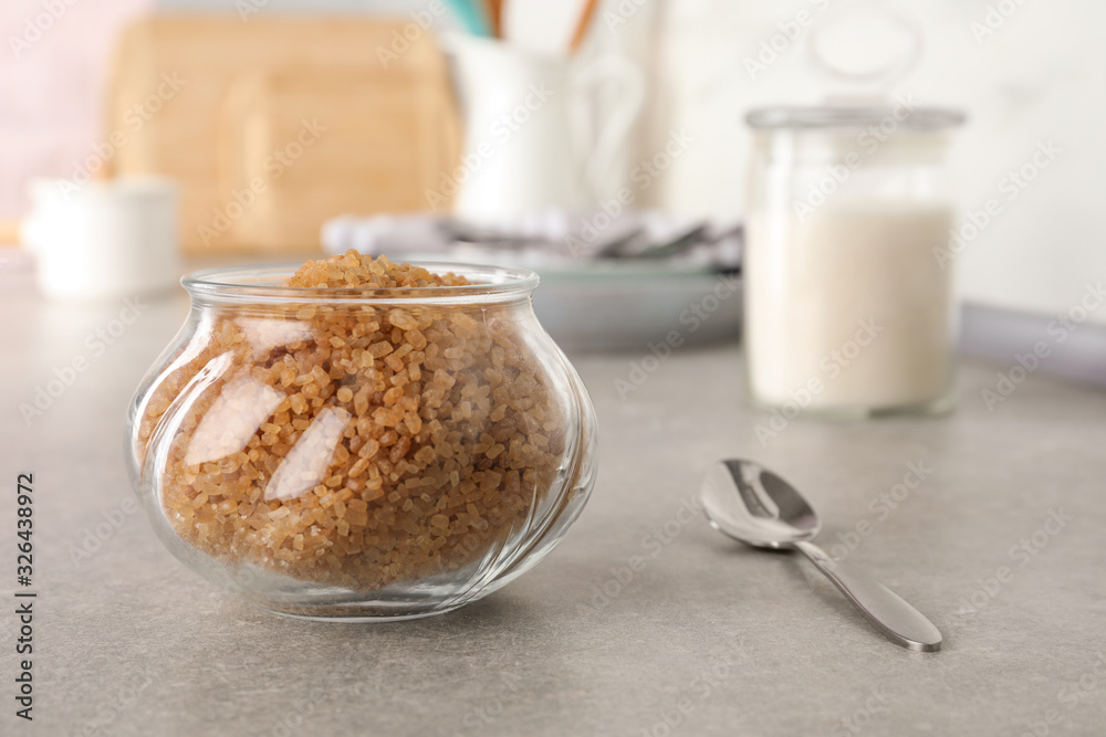 Glass bowl with brown sugar on grey table Glass bowl with brown sugar on grey table