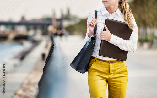 Portrait of Young attractive businesswoman walking while holding document