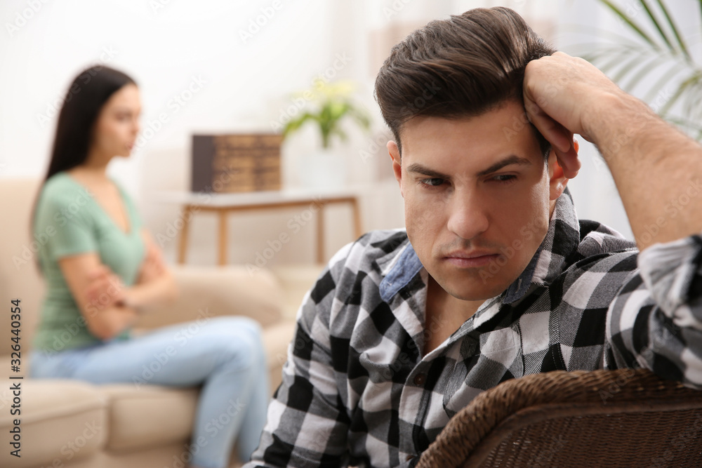 Obraz premium Unhappy man after quarrel with his girlfriend indoors. Relationship problems