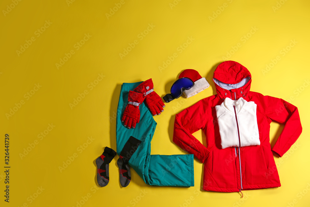 Stylish winter sport clothes on yellow background, flat lay