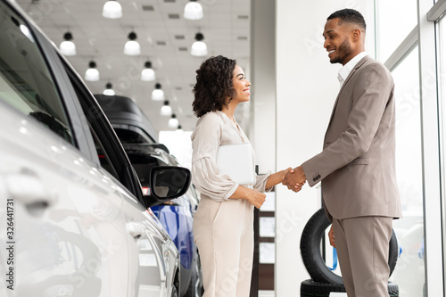 Afro Businessman Handshaking With Manager Girl Standing In Dealership Shop