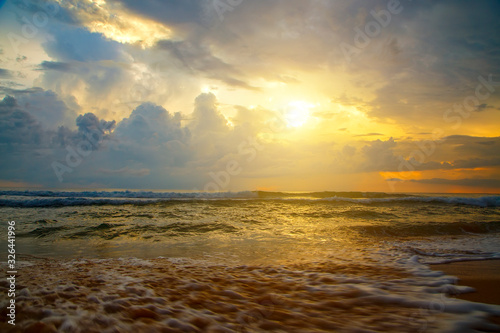 sun among clouds  beautiful yellow sunset over a sandy ocean beach of coast of Sri Lanka  Asia