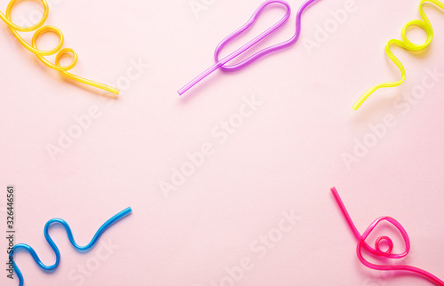 Five multi-colored tubules for drinks on a pink background. Straws for cocktails of different shapes. The concept of a holiday  celebration of events and parties. Place for text