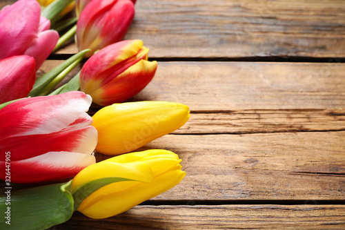 Beautiful spring tulips on wooden background, closeup. Space for text