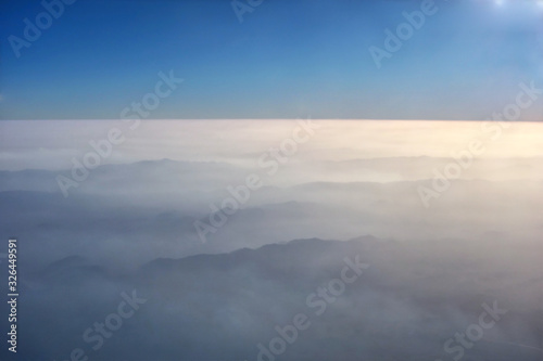 aerial view of mountains through clouds