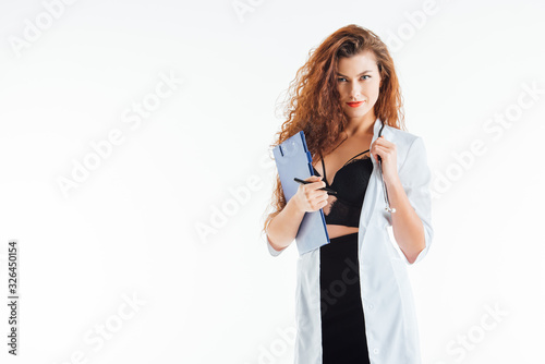 curly and sexy nurse holding clipboard isolated on white