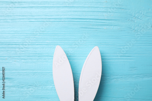 Decorative bunny ears and space for text on light blue wooden background, flat lay. Easter holiday © New Africa