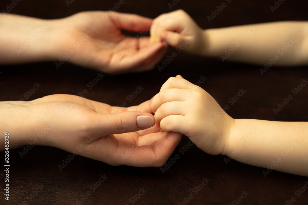 Holding hands, clapping like friends. Close up shot of female and kid's hands doing different things together. Family, home, education, childhood, charity concept. Mother and son or daughter, wealth.