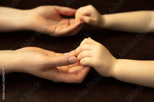 Holding hands  clapping like friends. Close up shot of female and kid s hands doing different things together. Family  home  education  childhood  charity concept. Mother and son or daughter  wealth.