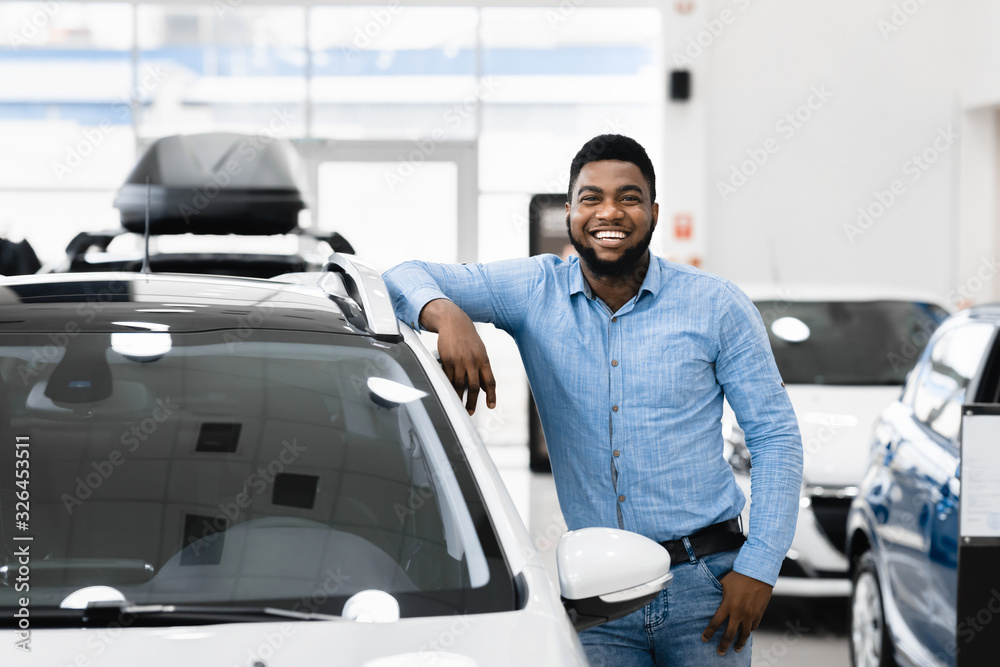 Afro Man Standing Posing Near New Auto In Dealership Store