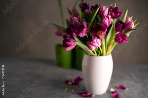 Fototapeta Naklejka Na Ścianę i Meble -  bouquet of tulips in white vase on stone grey background