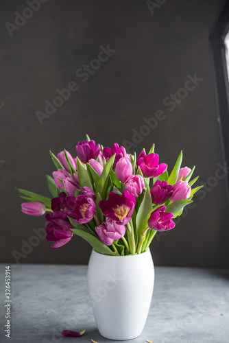 Fototapeta Naklejka Na Ścianę i Meble -  bouquet of tulips in white vase on stone grey background