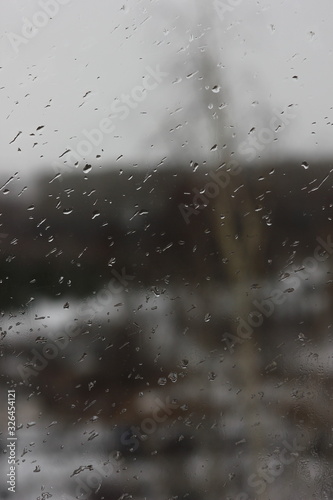 raindrops on the window on a blurred background of inclement weather