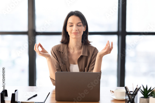 Foto Girl meditating in office coping with stress at work
