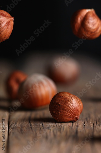 a hazelnut and a broken shell close up on a cracked wooden table