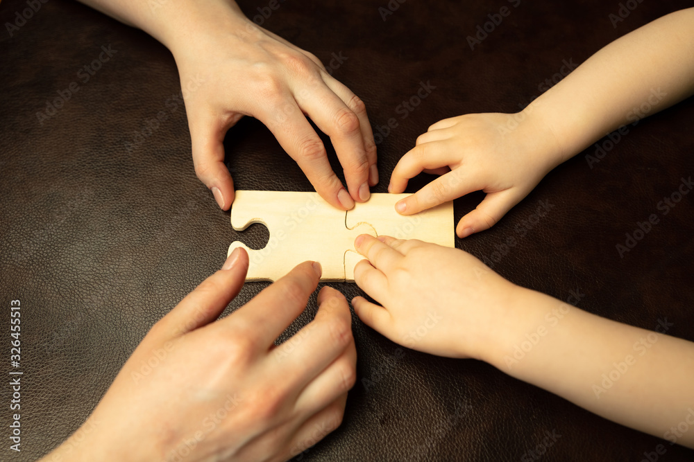 Collecting pazzles, building future. Close up shot of female and kid's hands doing different things together. Family, home, education, childhood, charity concept. Mother and son or daughter, wealth. - obrazy, fototapety, plakaty 