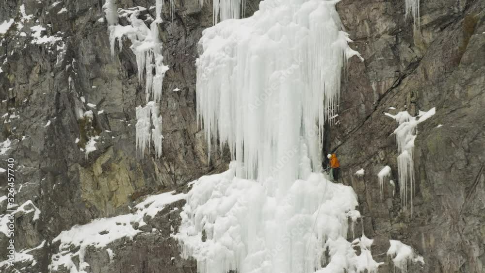 Extreme climbers on frozen cliff face Aerial reveal 4K Extreme climbers on frozen cliff face Aerial reveal 4K