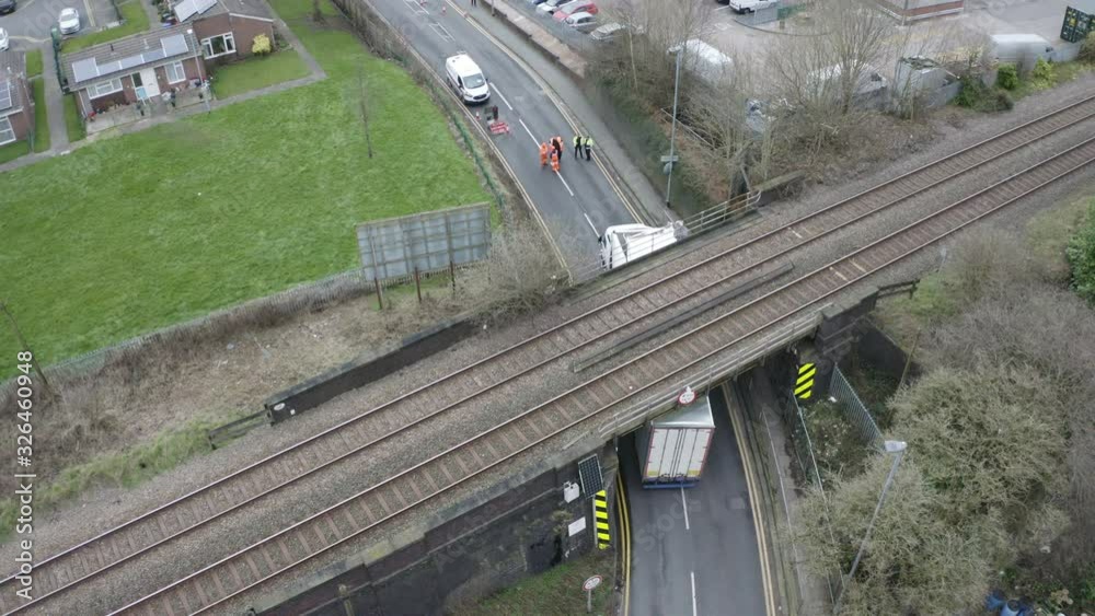 A UK Mail lorry crashes into a railway bridge on the busy anchor road, a busy commuter street in Longton, Stoke on Trent, HGV lorry crash, large haulage vehicle stuck under bridge, West Midlands A UK Mail lorry crashes into a railway bridge on the busy anchor road, a busy commuter street in Longton, Stoke on Trent, HGV lorry crash, large haulage vehicle stuck under bridge, West Midlands