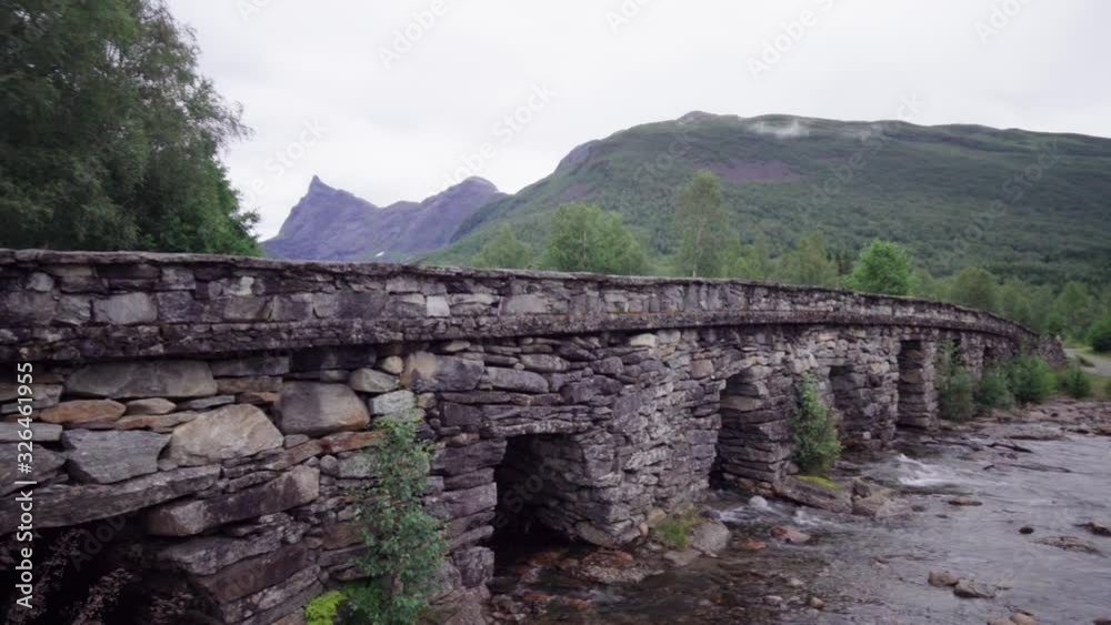 Old stone bridge with a high sharp mountain peak in the background - Norwegian mountain scenery