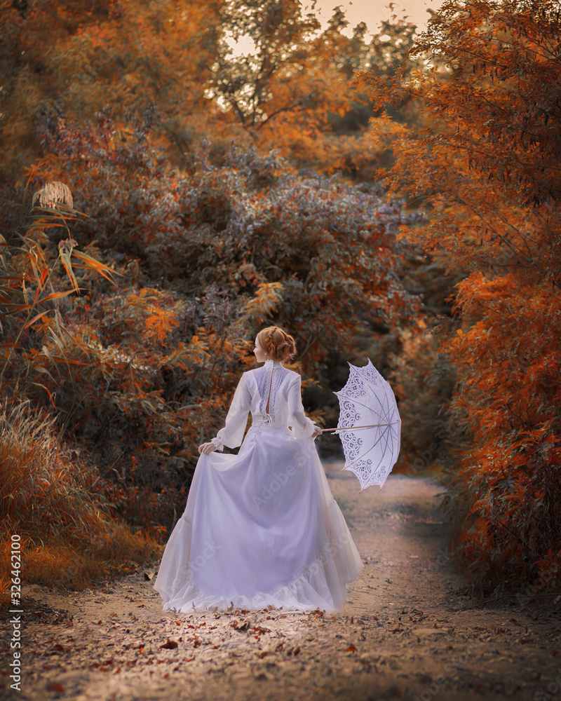 Backside view amazing cute young woman in beautiful fairy-tale image with fire red hair in white long dress holds white lace umbrella and walks along path in bright yellow autumn pictorial forest Backside view amazing cute young woman in beautiful fairy-tale image with fire red hair in white long dress holds white lace umbrella and walks along path in bright yellow autumn pictorial forest