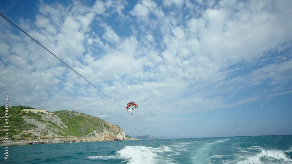 parasailing is done over the boat. parachute is flying over the sea. parachute attached to the