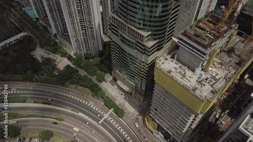 Aerial view of workers on the rooftop of a construction site of a high rise skyscraper with traffic passing down below in the Taikoo district of Hong Kong Island in the SAR of Hong Kong, China. photo