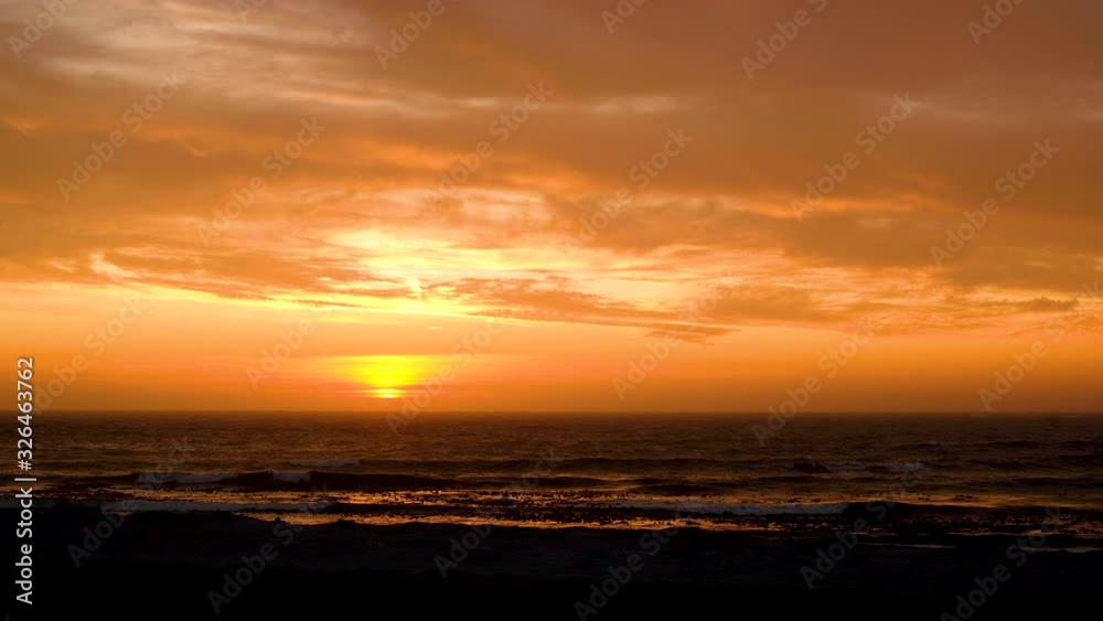 Sunset over ocean, light clouds causing impressive golden skies Sunset over ocean, light clouds causing impressive golden skies
