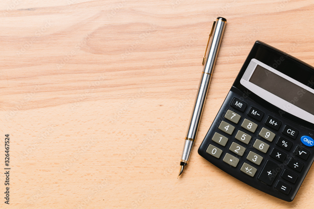 Accounting, financial concept, flat lay, calculator and pen on wooden table
