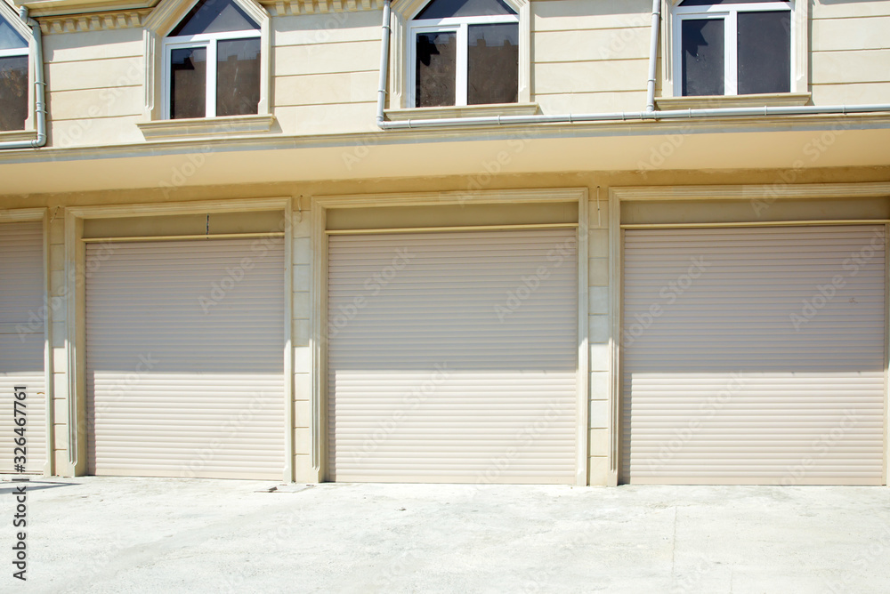 Shutter door or roller door and concrete floor outside .White Automatic shutters in a house . gates in the garage . Automatic Electric Roll-up Gate Or Push-up Door In The Modern Building  .