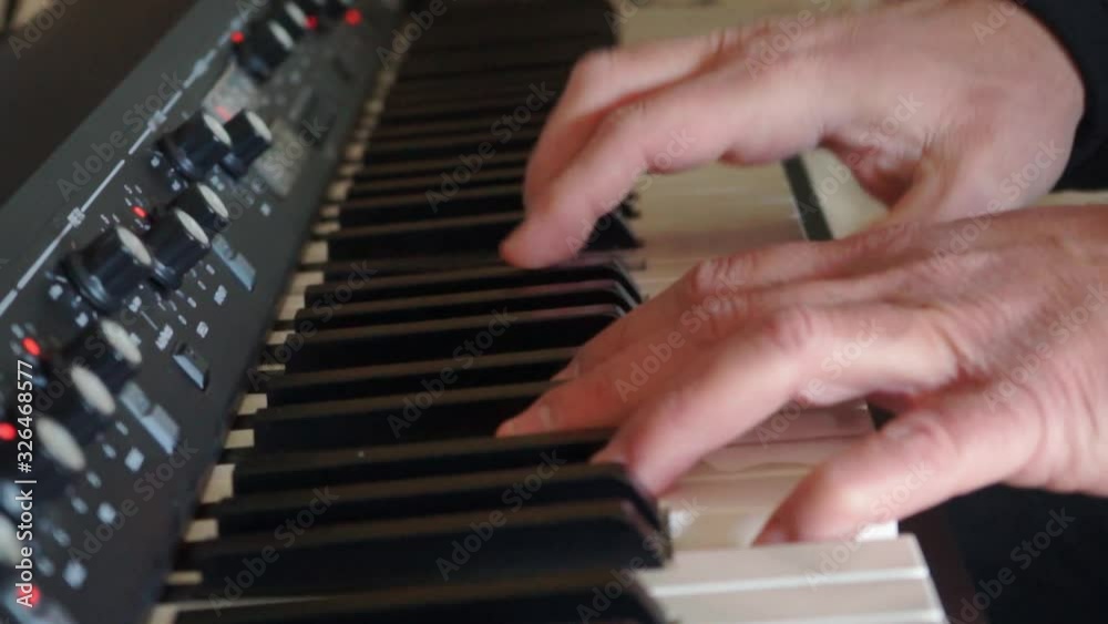 Caucasian adult in home studio playing synth. Side view, dolly effect close up Caucasian adult in home studio playing synth. Side view, dolly effect close up