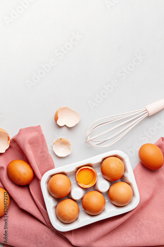 Eggs, towel in rustic style on light background. Organic ingredient, healthy food lifestyle concept. Easter background. Flat lay, copy space. Rustic table top view.