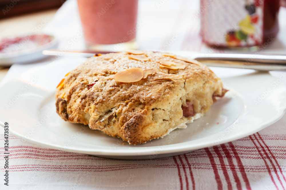Breakfast table with a home made coconut and rhubarb scone on a plate Breakfast table with a home made coconut and rhubarb scone on a plate