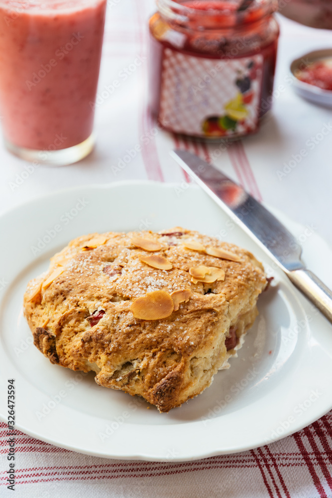 Breakfast table with a home made coconut and rhubarb scone on a plate