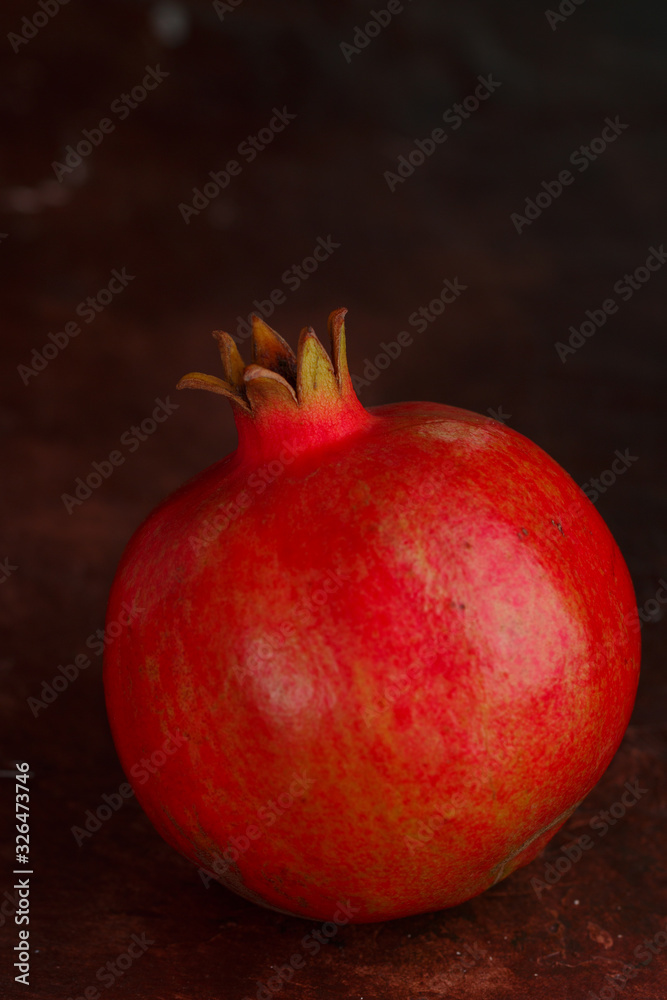 Ripe juicy organic whole pomegranate on a dark background. Fresh fruit. Vitamins. Healthy diet. Selective focus, copy space Ripe juicy organic whole pomegranate on a dark background. Fresh fruit. Vitamins. Healthy diet. Selective focus, copy space