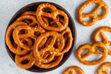 Mini pretzels with salt in a ceramic bowl close-up. Traditional German beer appetizer on a grey background. Selective focus, top view