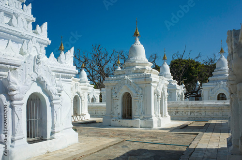 White stupas of Kuthodaw Pagoda contain worlds biggest book. Total of 729 kyauksa gu or stone-inscription caves with marble slab inside inscribed with buddhist text