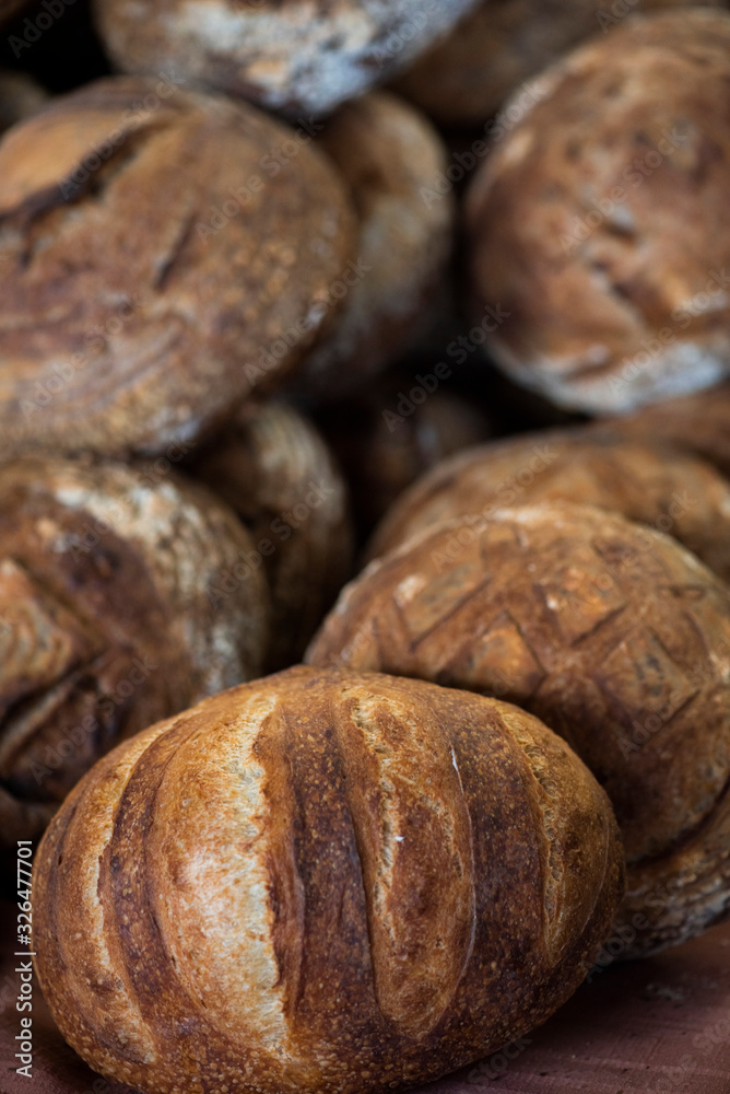 large assortment of freshly baked bread at local bakery, stacked loaves, artisan loaf of bread